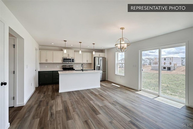 kitchen with white cabinetry, a center island with sink, pendant lighting, and appliances with stainless steel finishes