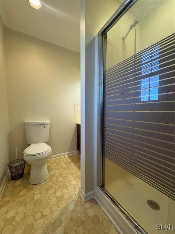 bathroom featuring vanity, an enclosed shower, crown molding, and toilet