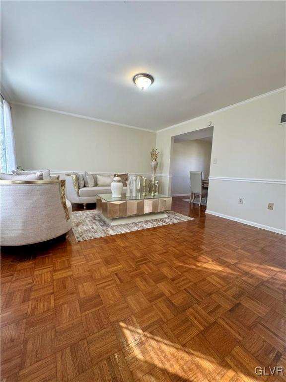 unfurnished living room featuring parquet floors and crown molding