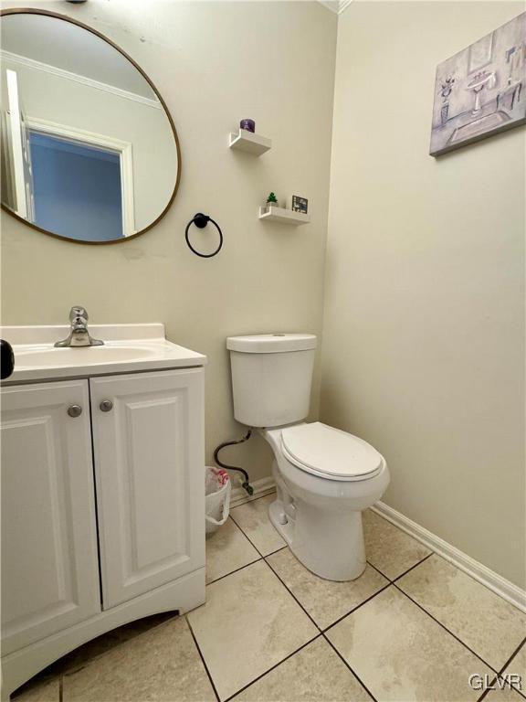 bathroom featuring vanity, ornamental molding, tile patterned floors, and toilet