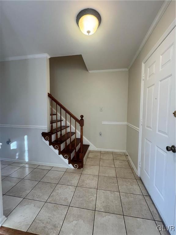 stairs featuring crown molding and tile patterned floors