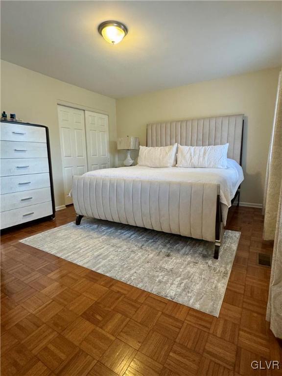 bedroom featuring a closet and dark parquet floors