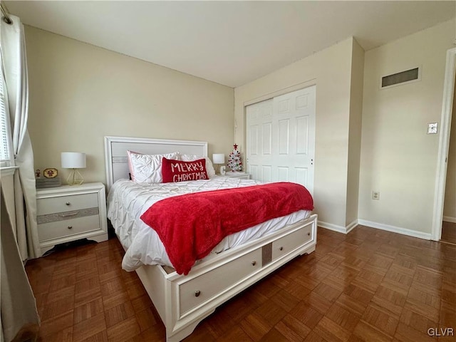 bedroom featuring dark parquet flooring and a closet