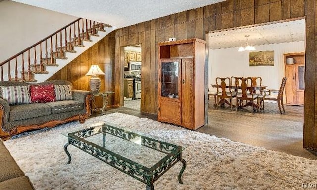 living room featuring hardwood / wood-style floors, wood walls, and a chandelier