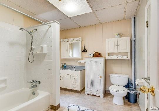 bathroom with  shower combination, toilet, and a paneled ceiling