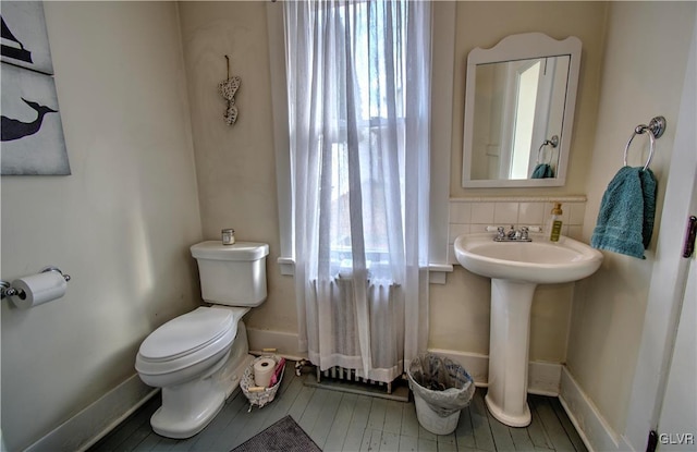 bathroom with toilet, plenty of natural light, and sink