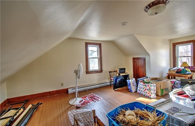 bonus room with wood-type flooring, vaulted ceiling, and a baseboard heating unit