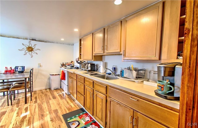 kitchen featuring light brown cabinets, white stove, light hardwood / wood-style floors, and sink