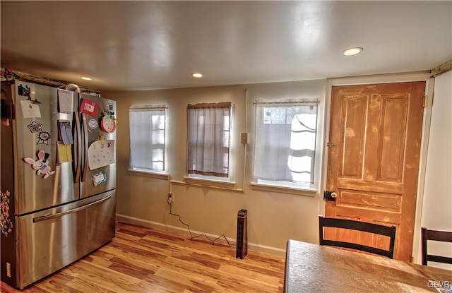 kitchen with a wealth of natural light, stainless steel fridge, and light hardwood / wood-style flooring