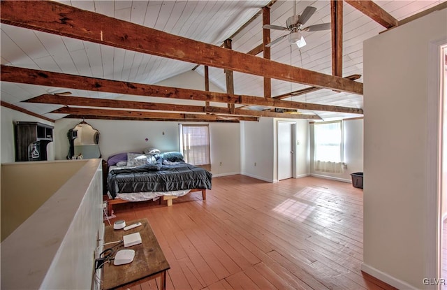 bedroom featuring lofted ceiling with beams, light hardwood / wood-style floors, and ceiling fan