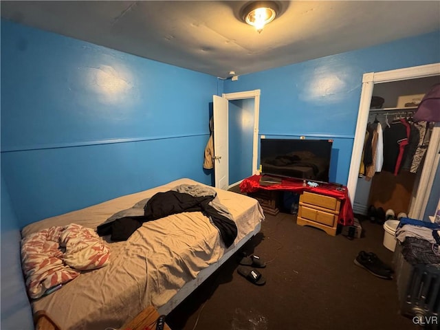 bedroom with concrete flooring and a closet