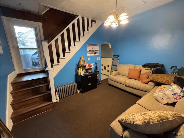 carpeted living room with radiator and a notable chandelier