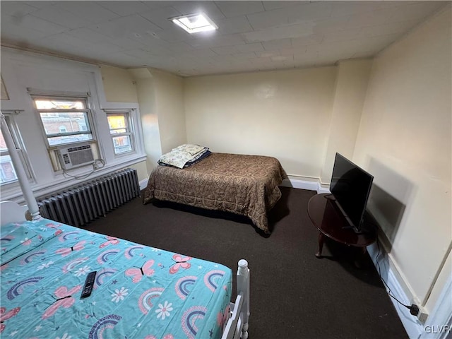 carpeted bedroom with radiator heating unit and cooling unit