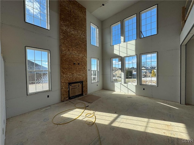 unfurnished living room with a towering ceiling and a wealth of natural light