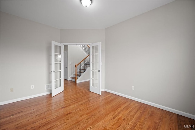 empty room with french doors and light hardwood / wood-style floors