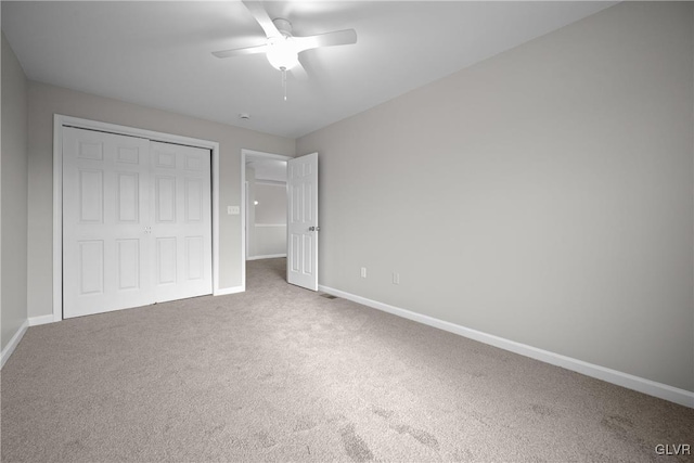 unfurnished bedroom with carpet floors, a closet, and ceiling fan