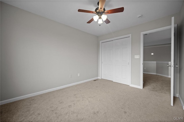 unfurnished bedroom featuring ceiling fan, light carpet, and a closet