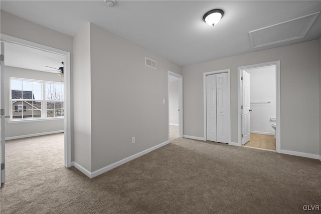 unfurnished bedroom with carpet flooring, ensuite bathroom, and a closet