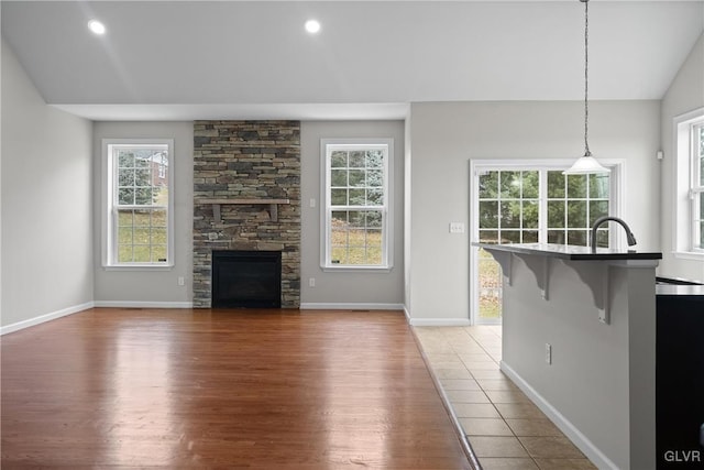 unfurnished living room with a fireplace, hardwood / wood-style flooring, and vaulted ceiling