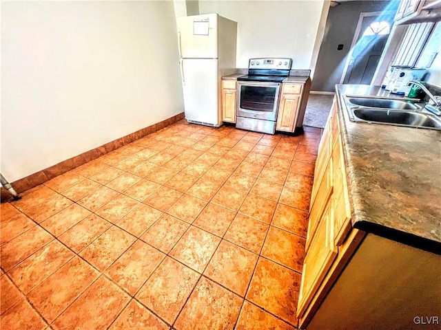 kitchen with sink, stainless steel range with electric cooktop, light tile patterned floors, and white refrigerator