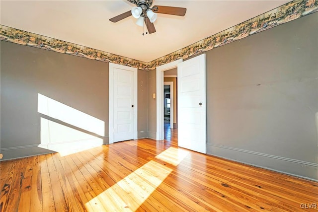 empty room with ceiling fan and hardwood / wood-style flooring