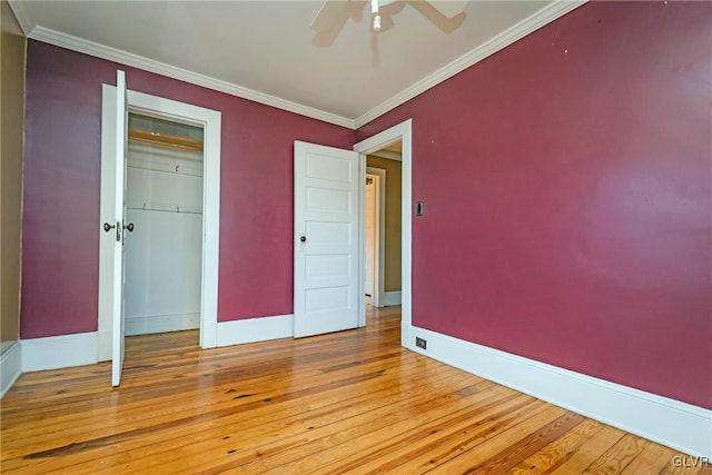 unfurnished bedroom with ceiling fan, a closet, ornamental molding, and light hardwood / wood-style flooring