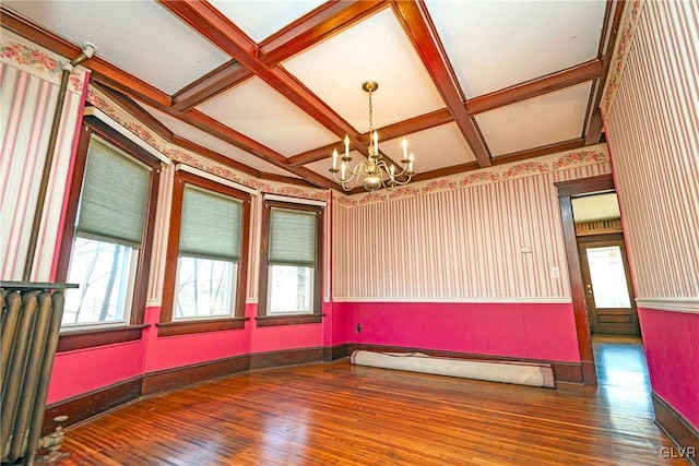 empty room featuring hardwood / wood-style floors, beam ceiling, and coffered ceiling