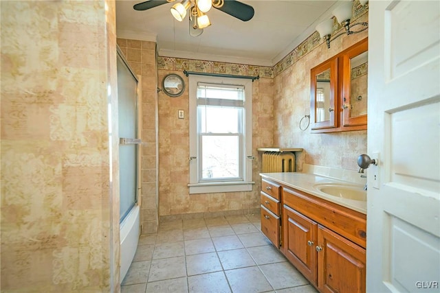 bathroom with vanity, crown molding, tile patterned flooring, ceiling fan, and enclosed tub / shower combo