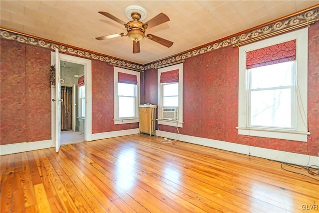 empty room with hardwood / wood-style floors, ceiling fan, and cooling unit