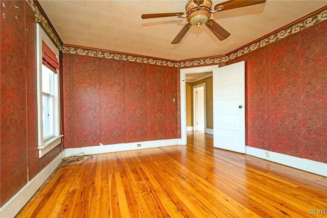 unfurnished room featuring hardwood / wood-style floors, ceiling fan, and crown molding