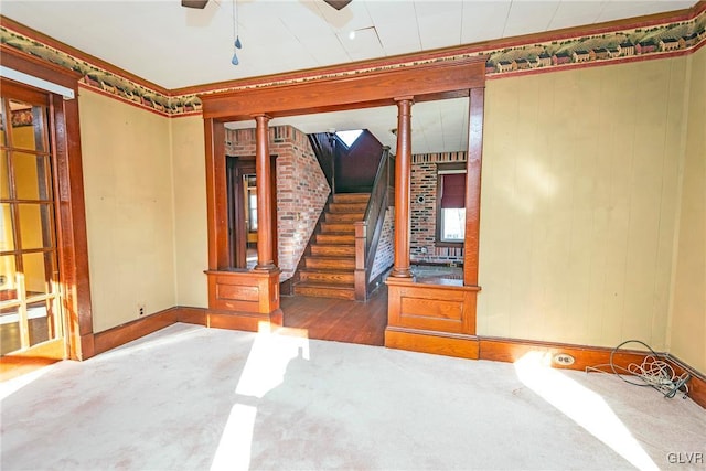 spare room with wood-type flooring, decorative columns, and ceiling fan