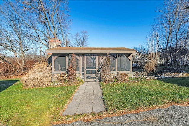 view of front of house with a sunroom and a front yard