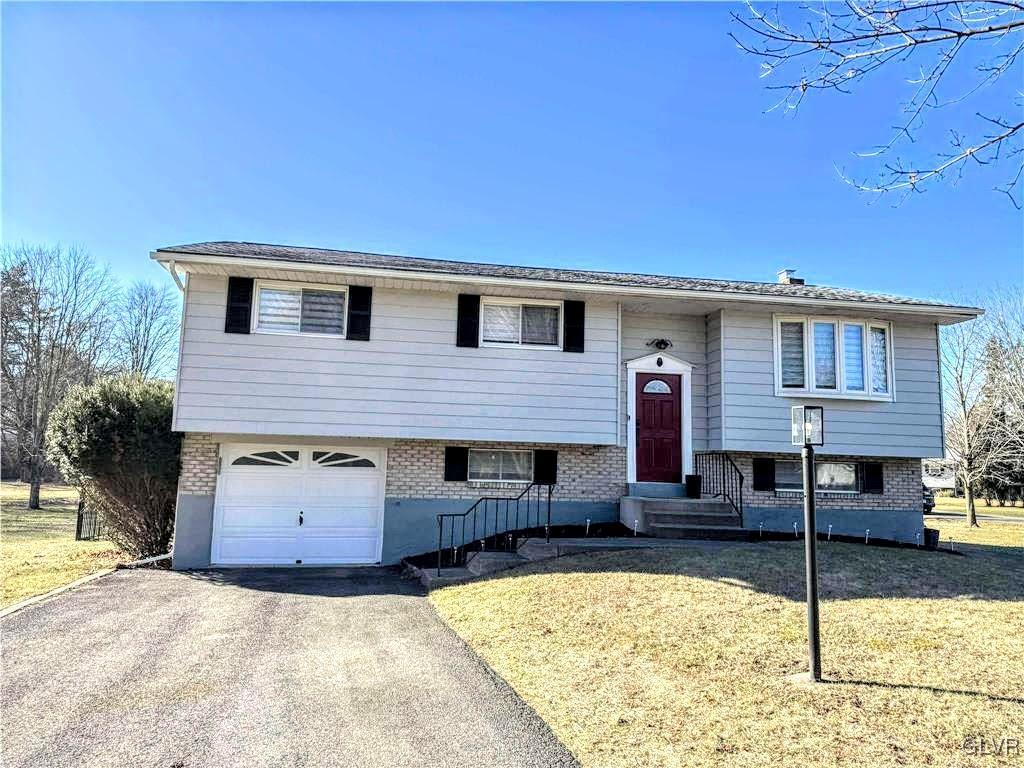 split foyer home featuring a garage and a front lawn