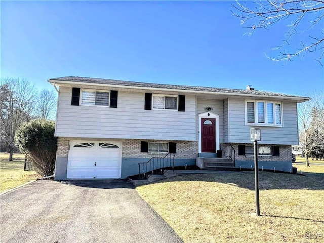 split foyer home featuring a garage and a front lawn