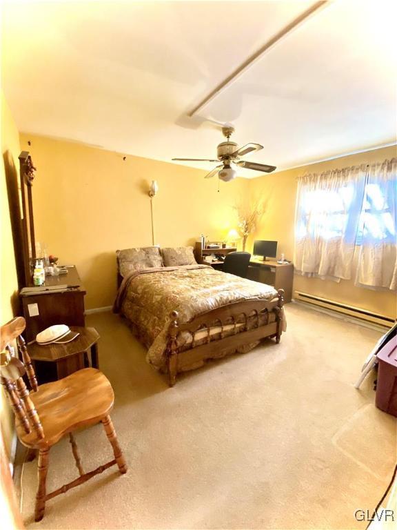 bedroom with ceiling fan, light carpet, and a baseboard radiator