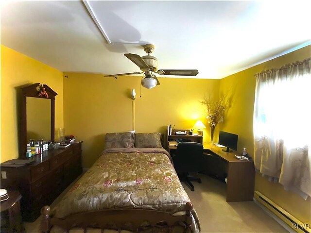 carpeted bedroom with ceiling fan and a baseboard heating unit