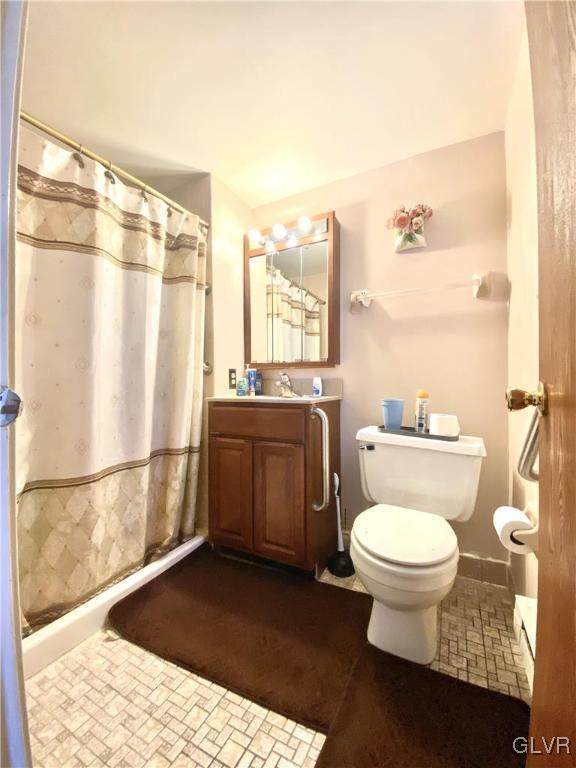 bathroom with a shower with curtain, vanity, and toilet