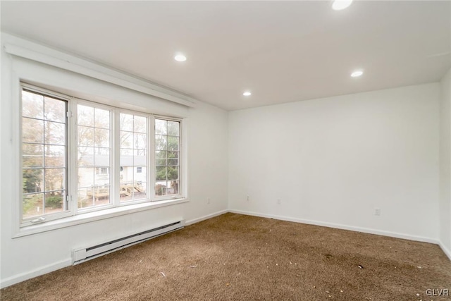 spare room with plenty of natural light, carpet floors, and a baseboard heating unit