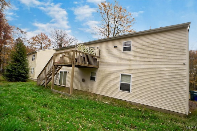 rear view of property with a lawn and a wooden deck