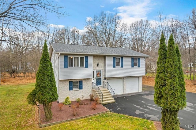 bi-level home with a front yard and a garage