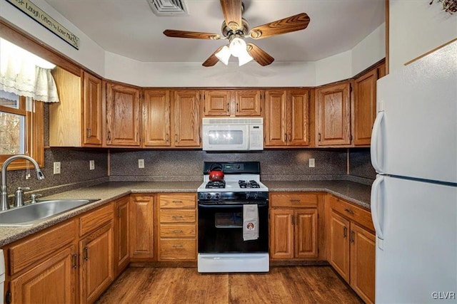 kitchen with decorative backsplash, sink, wood-type flooring, and white appliances