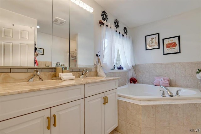 bathroom featuring vanity and tiled tub