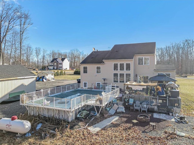 back of house featuring a fire pit, a gazebo, and a wooden deck