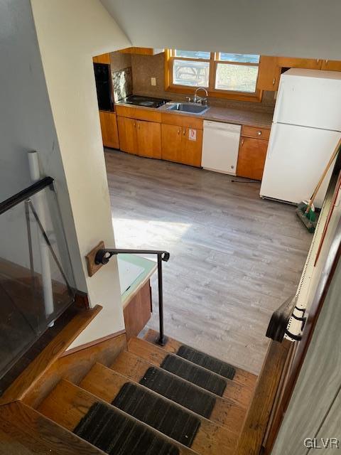 interior space featuring sink, white appliances, and light hardwood / wood-style flooring