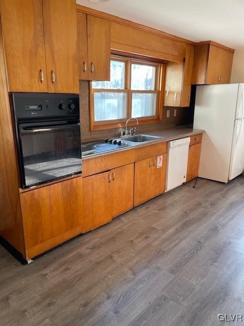 kitchen with dark hardwood / wood-style floors, white appliances, and sink