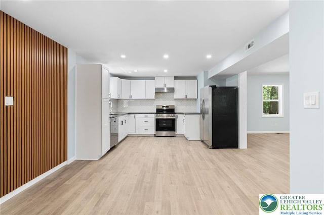 410 Sunset Forest Dr, Pike, PA 18428 - kitchen featuring appliances with stainless steel finishes, under cabinet range hood, light wood finished floors, tasteful backsplash, and white cabinets