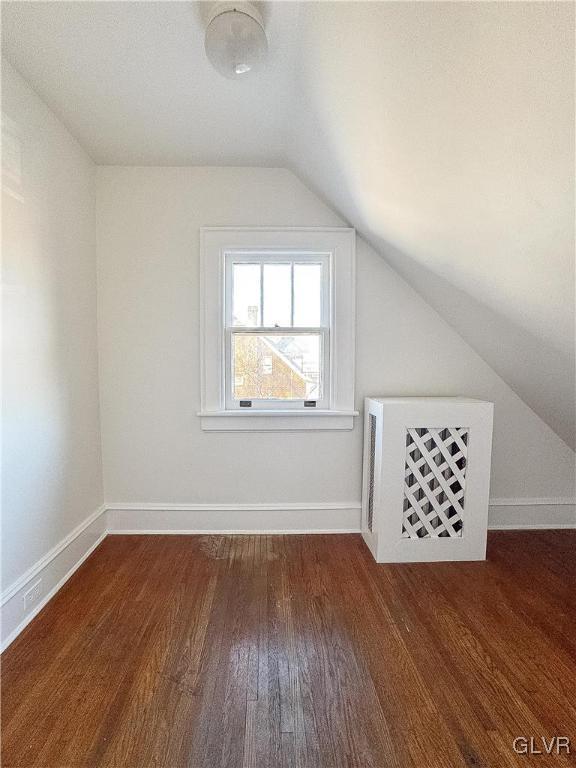 bonus room with dark hardwood / wood-style flooring and vaulted ceiling