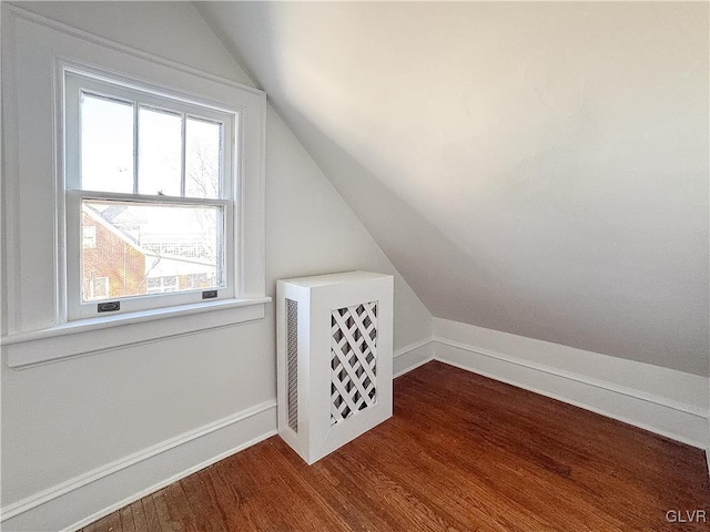 bonus room with hardwood / wood-style floors and vaulted ceiling