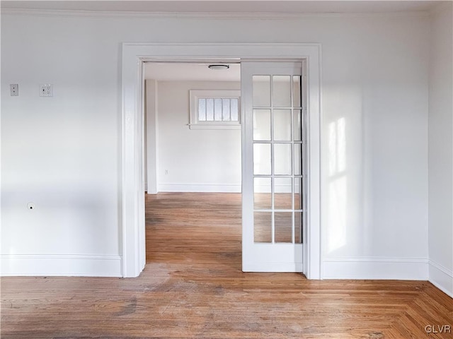 unfurnished room featuring hardwood / wood-style floors, french doors, and ornamental molding