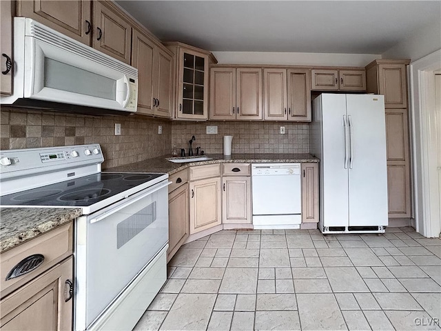 kitchen with white appliances, sink, light tile patterned floors, tasteful backsplash, and stone countertops